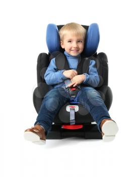 Baby boy buckled in car seat on white background�
