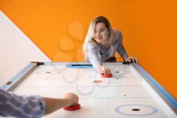 Young women playing air hockey indoors�