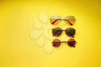 Different stylish sunglasses on color background�
