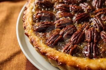 Plate with tasty pecan pie on table, closeup�