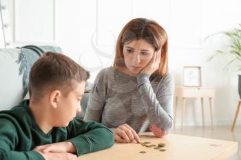 Sad mother with son counting alimony at home�