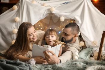 Happy family reading book at home�