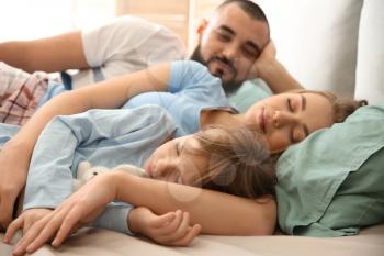Happy family sleeping in bed at home�