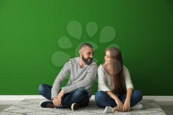 Young couple sitting on carpet in new empty flat�
