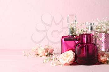 Bottles of female perfume and flowers on table�
