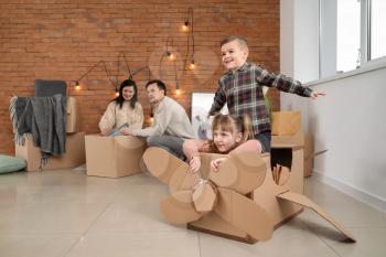 Children playing with cardboard box on moving day�
