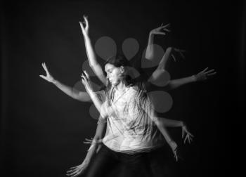 Stroboscopic photo of young woman with moving arms on dark background�