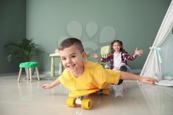 Cute little boy with skateboard at home�