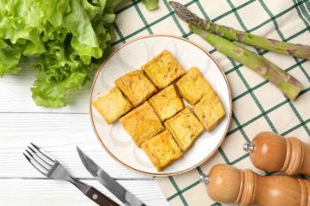 Plate with tasty tofu cheese on white table�