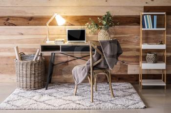 Interior of modern room with comfortable workplace near wooden wall�