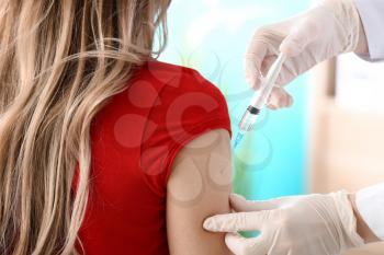 Doctor vaccinating woman against flu in clinic�