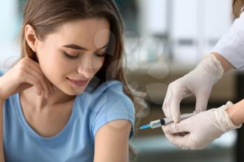 Doctor vaccinating woman against flu in clinic�