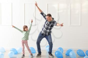 Father and his cute little daughter dancing in room with balloons�