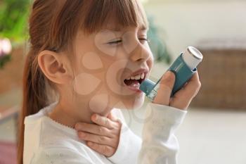 Little girl with inhaler having asthma attack at home�