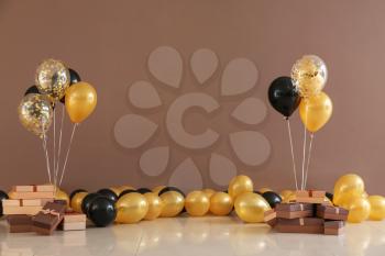 Gift boxes and balloons near color wall�