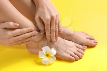 Legs and hands of young woman with beautiful pedicure and manicure on color background�