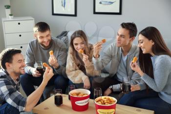 Group of friends eating nuggets at home�