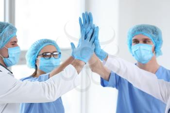 Team of doctors giving high five in clinic�