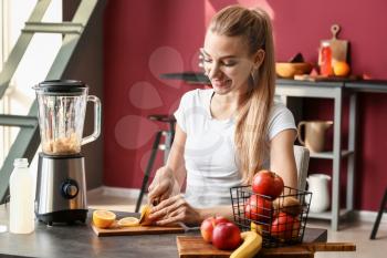 Young woman making healthy smoothie at home�