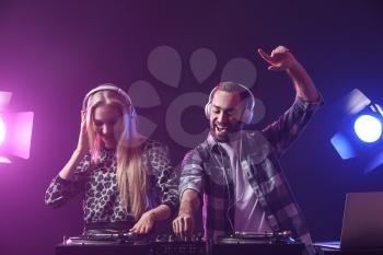 Male and female DJs playing music in club�