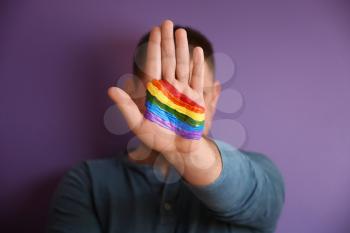 Man with painted palm against color background. LGBT concept�