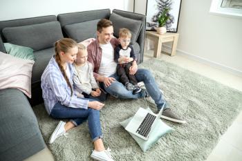 Happy family watching cartoons at home�