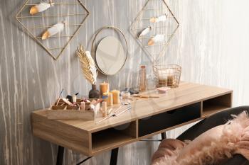 Dressing table with set of cosmetics near grunge wall�