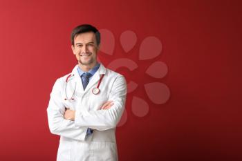 Male pediatrician on color background�