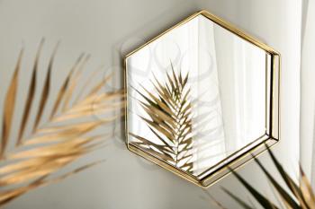 Mirror and golden tropical leaves in room�