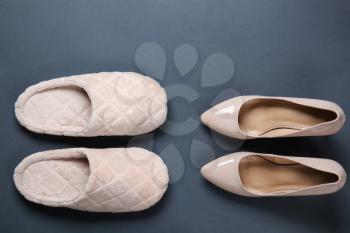 Soft slippers and high heeled shoes on dark background. Concept of choosing between comfortable and beautiful footwear�