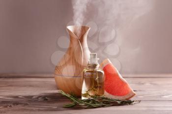 Aroma oil diffuser, rosemary and grapefruit on table�