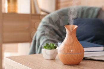Aroma oil diffuser on table in room�