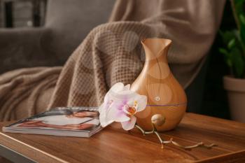 Aroma oil diffuser on table in room�