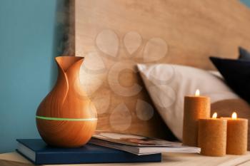 Aroma oil diffuser on table in bedroom�