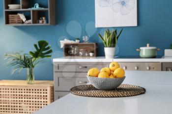 Bowl with fresh lemons on table in interior of modern kitchen�
