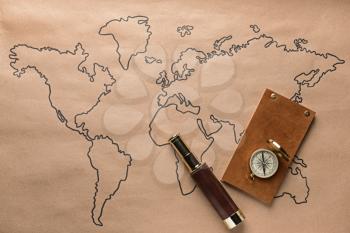 Spyglass, compass and notebook on world map. Travel concept�
