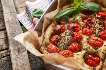Baking dish with tasty Italian focaccia on wooden table�