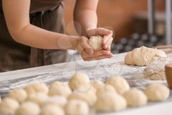 Female baker cooking buns in kitchen�
