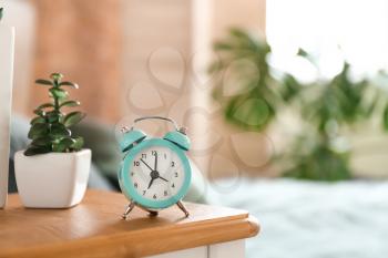 Alarm clock on table in bedroom�