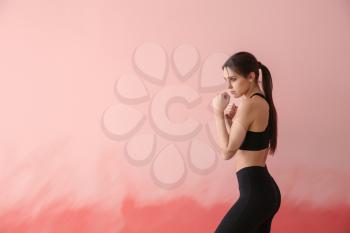 Sporty female boxer on color background�