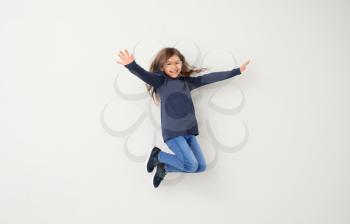 Jumping little girl on white background�