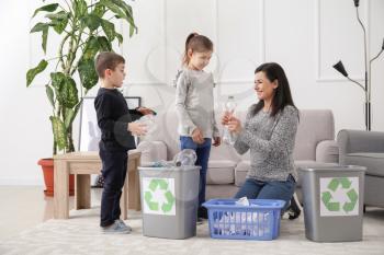 Family sorting garbage at home. Concept of recycling�