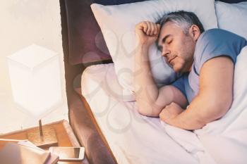 Mature man sleeping in bed at home�