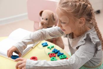 Little girl composing words of letters at speech therapist office�