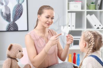 Speech therapist working with little girl in office�