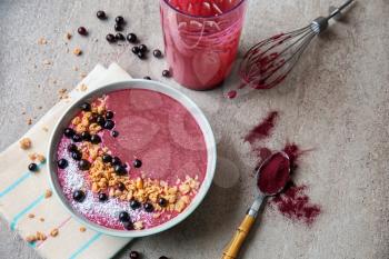 Bowl with tasty acai smoothie on grey table�