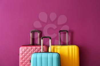 Packed suitcases on color background�