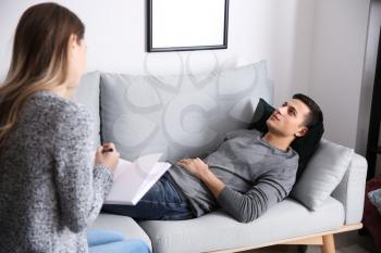 Female psychologist working with patient lying on sofa in her office�