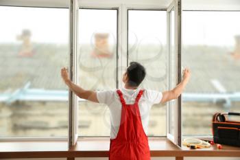 Young worker checking window after repair�