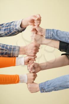 Group of people holding hands together on light background. Concept of unity�